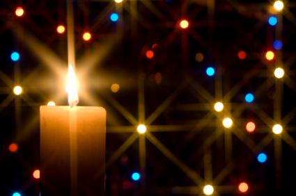 Christmas candle surrounded by glowing Christmas lights